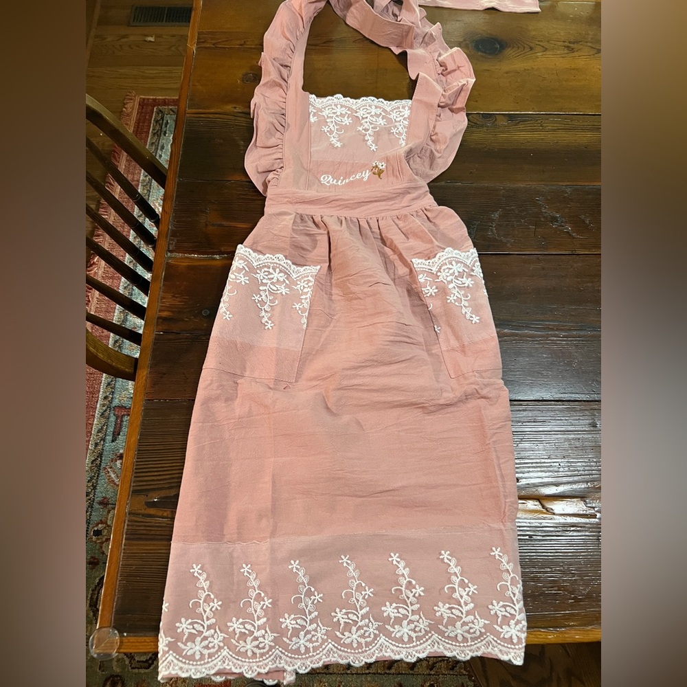 Pink embroidered floral lace apron for women. Personalized with“Quincey”